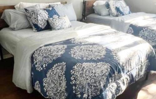 a bedroom with two beds with blue and white sheets at Turquoise Gem in Philadelphia