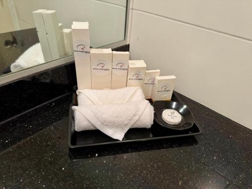 a tray with towels and a clock in a bathroom at ROYAL PARK HOTEL @ UNITEN in Kajang