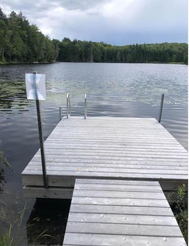 a dock on a lake with a sign on it at Luxury Lake Loghouse - Mont Tremblant in Labelle