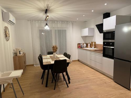 a kitchen and dining room with a table and chairs at Le Cocon du Paradis à 4 min du Zoo de Beauval in Saint-Aignan