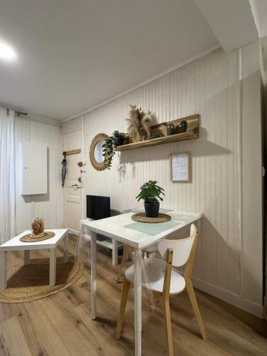 une salle à manger avec une table et des chaises blanches dans l'établissement Studio centre ville Séte, à Sète