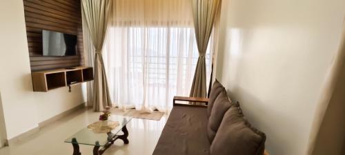 a living room with a couch and a glass table at Belle-Vue Holiday Homes - 1BHK Apartments in Panchgani
