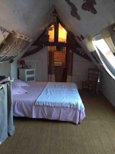 une chambre avec un lit dans un grenier dans l'établissement Jolie maison type Flamande avec 2 chambres, à Saint-Amand-les-Eaux