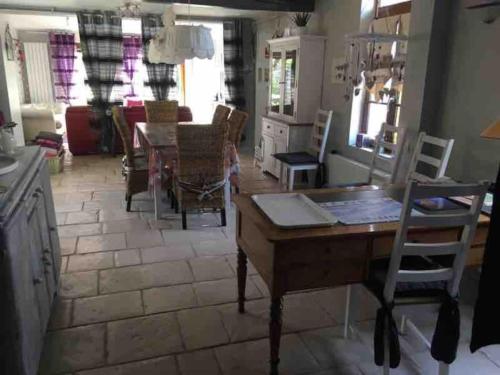 una cucina e una sala da pranzo con tavolo e sedie di Jolie maison type Flamande avec 2 chambres a Saint-Amand-les-Eaux