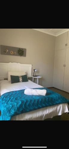 a bedroom with a bed with a blue blanket at Straebe Stay in Bloemfontein