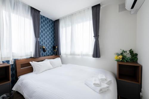 a bedroom with a white bed with two towels on it at FC Farnest Niseko in Kutchan