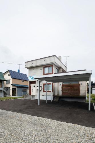 a white house with a garage in a parking lot at FC Farnest Niseko in Kutchan