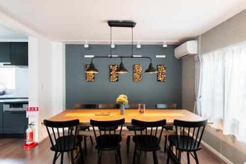 a dining room with a wooden table and black chairs at FC Farnest Niseko in Kutchan