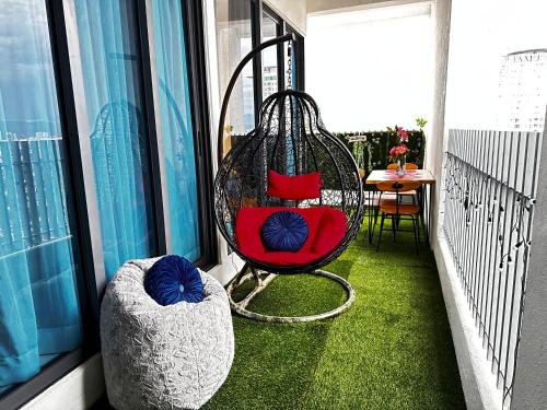 a balcony with a swing and a table on a balcony at The Luxe Colony Klcc By NTR Resources in Kuala Lumpur