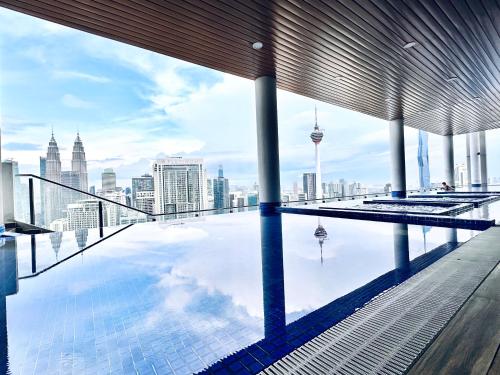 a swimming pool on top of a building with a city skyline at The Luxe Colony Klcc By NTR Resources in Kuala Lumpur