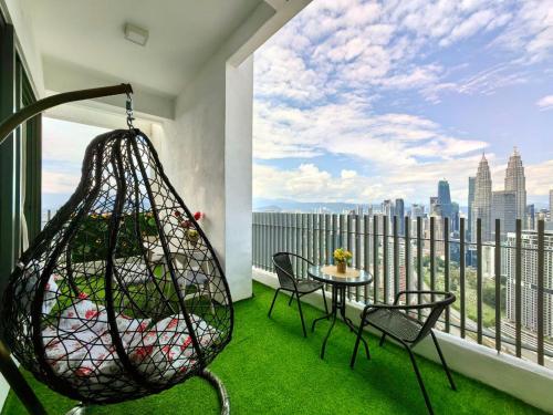 a balcony with a swing and a table and chairs at The Luxe Colony Klcc By NTR Resources in Kuala Lumpur