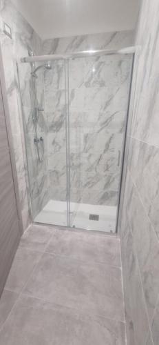a shower with a glass door in a bathroom at Hotel Movida in Casoria