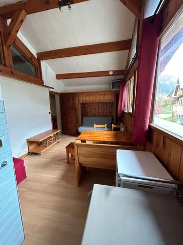 une chambre avec une table, un banc et une fenêtre dans l'établissement Studio 4p Louedza, à Pralognan-la-Vanoise