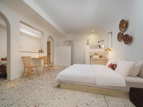 a white bedroom with a large bed and a table at YiXi Designer Hotel - Xi'an Bell Tower & Ming City Wall & T'ang Dynasty Ever-Bright City in Xi'an