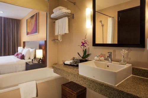 a bathroom with a sink and a large mirror at Somerset Hoa Binh Hanoi in Hanoi