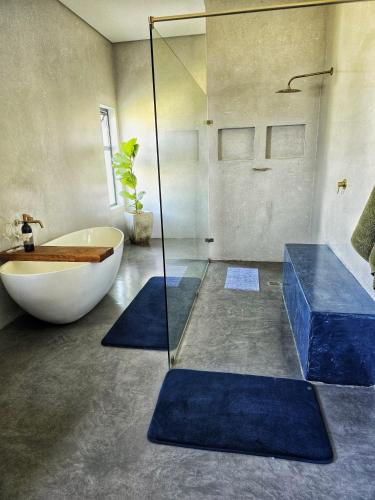 a bathroom with a tub and a sink and a bath tub at Sapphire St Helena bay in St. Helena Bay