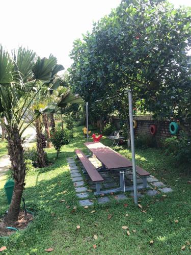 a picnic table in the grass next to a tree at ST Homestay Tản Lĩnh - Venuestay in Mỹ Khê