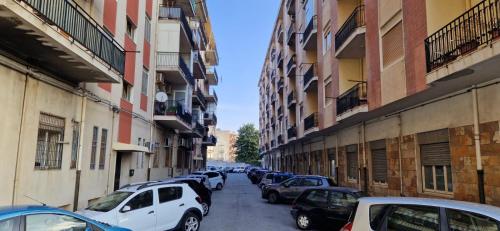 a row of cars parked on a street with buildings at La casa di Andrea in Messina