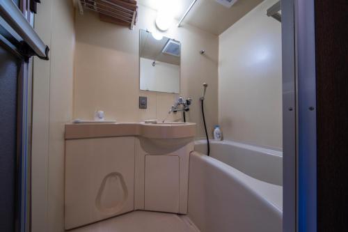 a bathroom with a sink and a bath tub at Few Days Condominium 602 in Jozankei