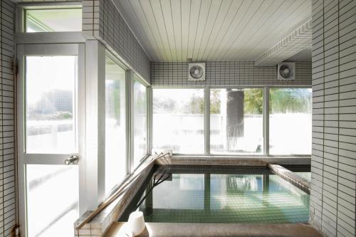 a swimming pool in a room with windows at Few Days Condominium 602 in Jozankei