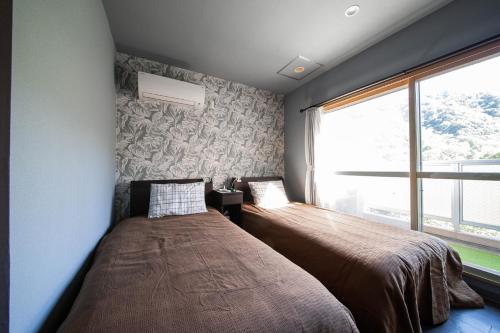 a bedroom with a bed and a large window at Few Days Condominium 602 in Jozankei