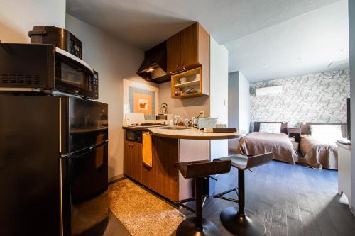 a kitchen with a sink and a bed in a room at Few Days Condominium 602 in Jozankei