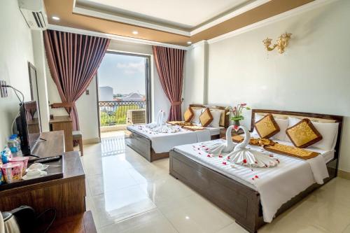 a hotel room with two beds and a balcony at Dat Anh Hotel in Hue