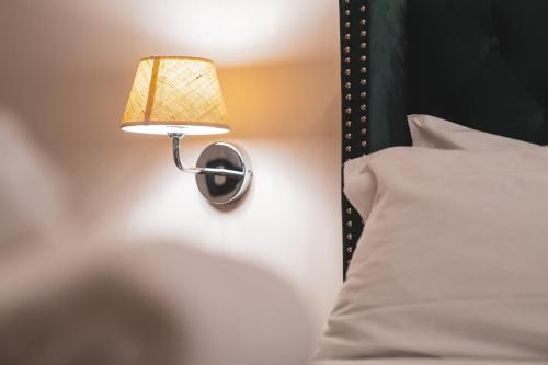 a lamp attached to a wall next to a bed at Carlo Felice Boutique Hotel in Turin