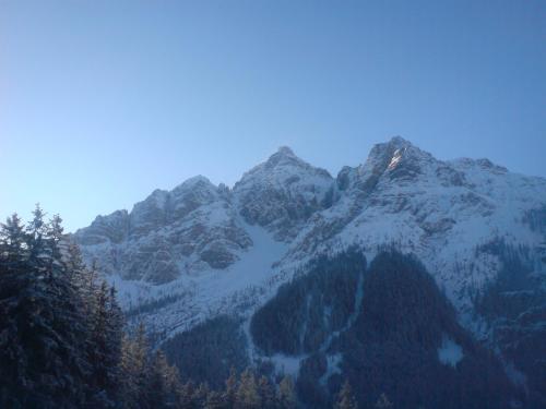 a mountain range with snow covered mountains with trees at Haus Hubertus in Mieders