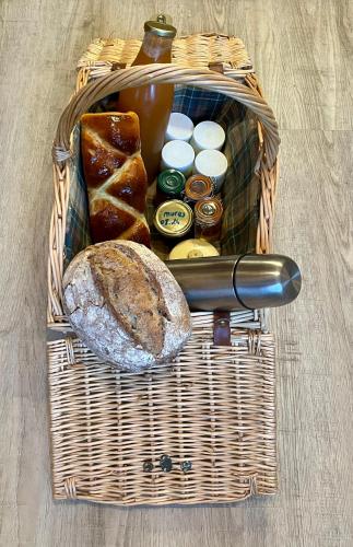een picknickmand met brood, boter en diverse kruiden bij Parenthèse en forêt - Lodge BALIVEAU in Le Bez