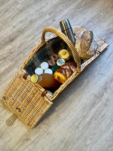 a picnic basket with bread and other items in it at Parenthèse en forêt - Lodge Hautbois 2-5 personnes dans le Sidobre in Le Bez