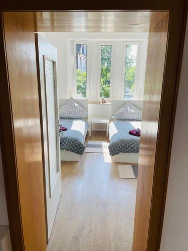 a room with two beds and two windows at Top Apartments in Kamen - Cozystays in Kamen