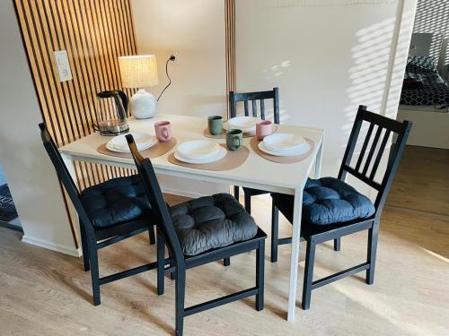 a dining room table with chairs and a white table with plates at Top Apartments in Kamen - Cozystays in Kamen