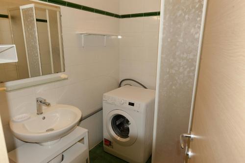 a bathroom with a washing machine and a sink at COCON AUX SENTEURS de CORSE et VUE EXCEPTIONNELLE in Linguizzetta