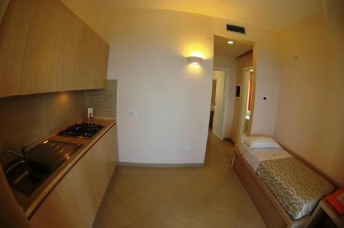 a room with a kitchen with a bed in it at Hotel Villaggio Cala Di Volpe in Capo Vaticano