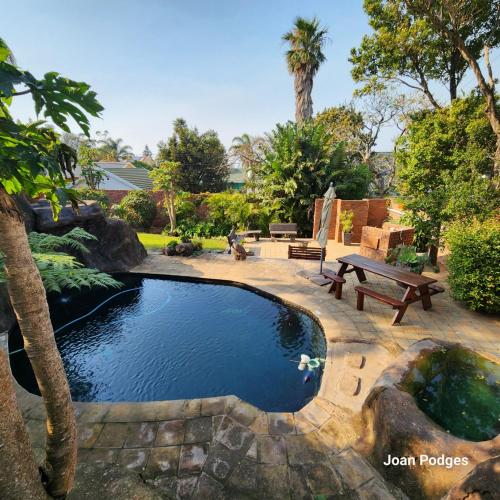 a pool in a yard with a picnic table and a bench at Bon A Vie Self-catering and b&b Gonubie Full Solar Power, no load shedding! in Gonubie