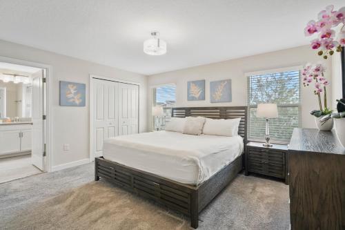 ein Schlafzimmer mit Bett, Schreibtisch und Fenstern in der Unterkunft 900 Pebble Beach Drive in Kissimmee