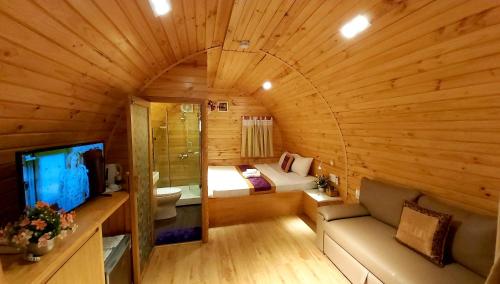 a room with a bed and a couch in a cabin at Milan Corner Hotel in Vung Tau