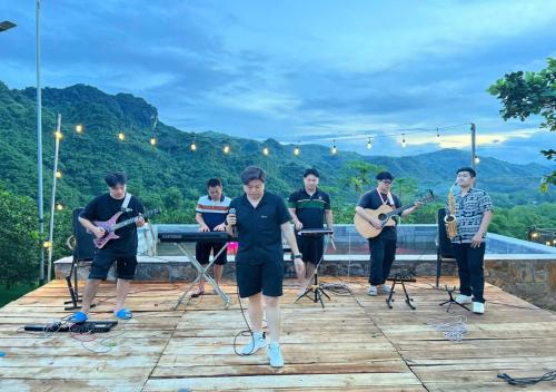 a group of people playing music on a deck at Ora Hill Retreat in Cao Phong