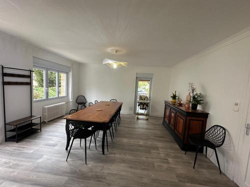 une salle à manger avec une table et des chaises en bois dans l'établissement Gite Bonheur du Pré-Salé, à Pontorson