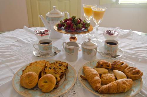 een tafel met twee borden gebak en kopjes koffie bij Angel Cave Houses in Oia