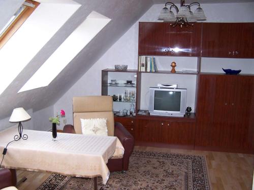 a living room with a table and a tv at Ferienwohnungen Seewald in Teterow