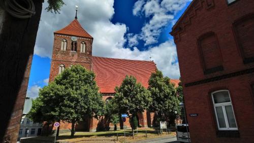 a large red brick building with a clock tower at Ferienwohnungen Seewald in Teterow