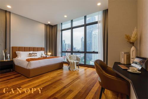 a bedroom with a bed and a desk and a large window at The Manor Signature Residence, Kuala Lumpur in Kuala Lumpur