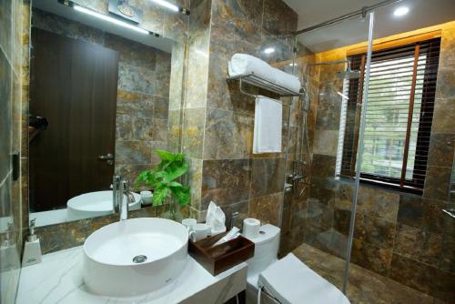 a bathroom with a sink and a toilet and a shower at Flamigo Dai Lai Resort - Villa Chủ Tự Doanh in Ngọc Quang
