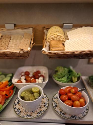 a bunch of bowls of vegetables on plates on a shelf at Hotell Rådhuset in Lidköping