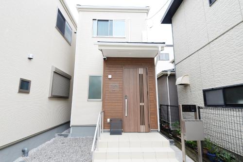 a wooden door on the side of a building at NYHotel 1 新宿2階建て4室1バスルーム1シャワー2トイレ in Tokyo