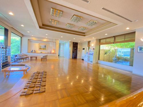 a large room with a wooden floor and a table in it at Bekkan Yosanoso in Miyazu