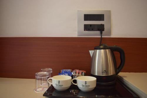 a coffee maker and two cups on a tray at Hotel The Haven - Centrally Heated and Air Conditioned in Kargil