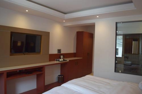 a hotel room with a bed and a mirror at Hotel The Haven - Centrally Heated and Air Conditioned in Kargil